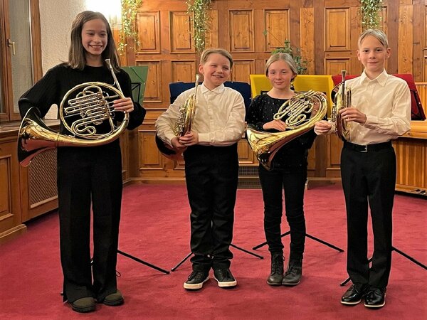 Vier junge Hornisten präsentieren sich und ihr Instrument.