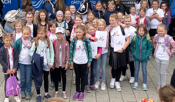 Es sind die Kinder des Kinderchores Grundschule Niederau vor der Ballsportarena zu sehen.