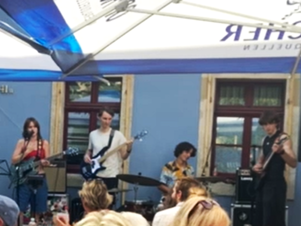 Die Band "dreißiger Zone" spielt vor Publikum. Es sind Schüler zu sehen die Gitarre, Bass und Schlagzeug spielen. Eine Schülerin singt.