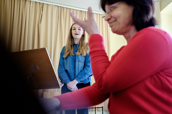 Eine Gesangslehrerin begleitet auf dem Klavier ihre Gesangsschülerin.