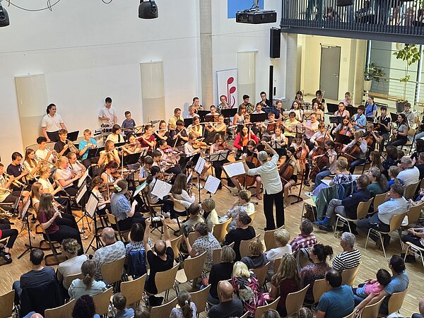 Ein großes Orchester spielt vor Publikum.