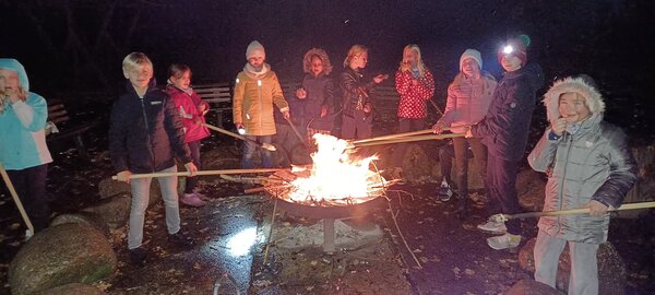 Die Schüler des Nachwuchs-Streichorchesters Großenhain sitzen am Lagerfeuer.