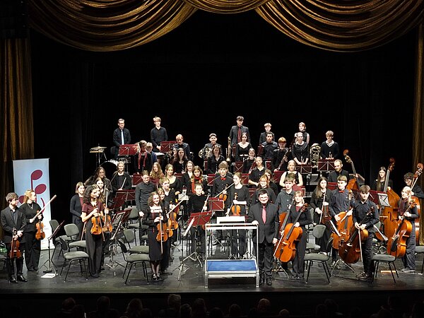 Das Jugendsinfonieorchester Radebeul steht auf der weihnachtlich geschmückten Bühne der Landesbühnen und spielt vor Publikum.