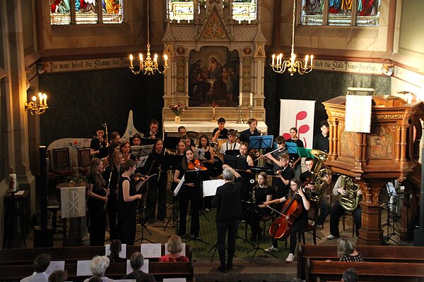 Das Orchester spielt vor Publikum, stehend im Altarraum der St.Martinskirche