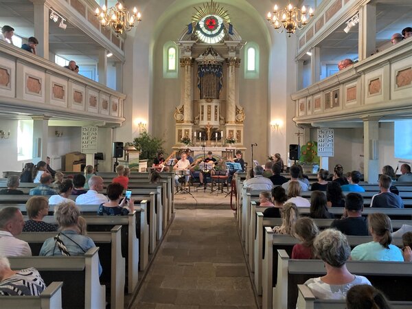 Das Publikum hört dem Gitarrenensemble zu.