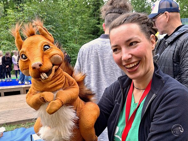 Das Maskottchen - Ein Eichhörnchen - als Handpuppe mit begeisterter Puppenspielerin.