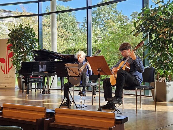Zwei junge Gitarristen musizieren im Saal der Landesärztekammer Sachsen.