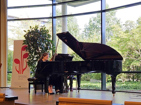 Zwei Pianistinnen spielen vierhändig an einem Flügel im lichtdurchfluteten Saal der Landesärztekammer Sachsen.