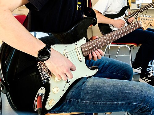 Zwei E-Gitarristen spielen ihr Instrument.