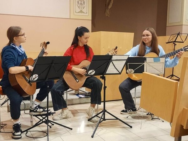 Ein Trio von Gitarrenschülern spielt in der Krankenhauskapelle von Radebeul.