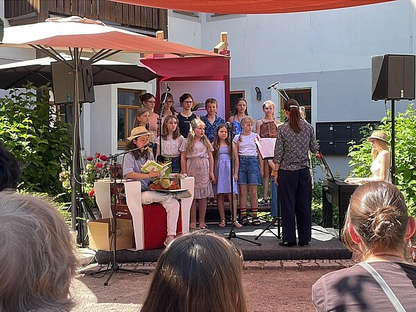 Kinder stehen und singen zum Literaturfest Meissen vor Publikum.