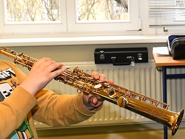 Ein Kind probiert das Sopran-Saxophon zu spielen.