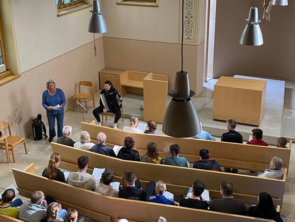 Es ist die Krankenhauskapelle Radebeul von innen, mit Publikum und Akkordeonspielerin, zu sehen.