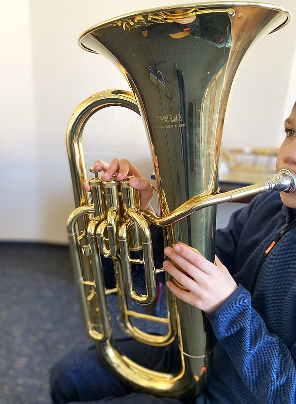 Ein Kind probiert die Tuba aus.
