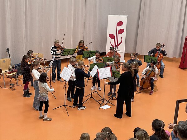 Die jungen Talente der Musikschule stehen auf der Bühne im Louisenstift Radebeul und präsentieren ein Stück vor Publikum unter der Leitung von Frau Linke.