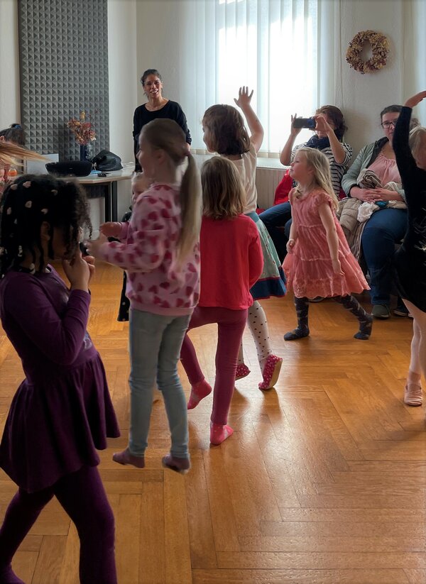 Kinder tanzen durch den Raum.