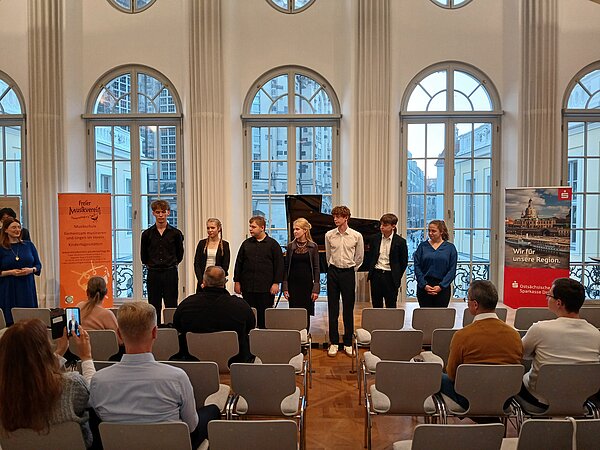 Die WettbewerbsteilnehmerInnen stehen auf dem Publikum und werden ausgezeichnet.