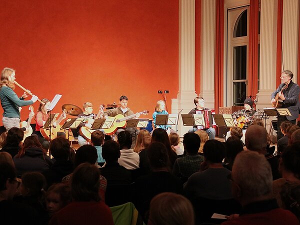 Das Gitarrenensemble sAitenstraße spielt vor Publikum in der Aula des Landesgymnasiums Sankt Afra.