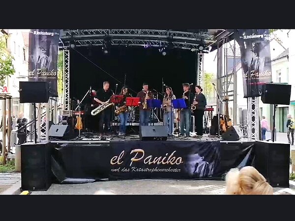 Das Saxophonensemble der Musikschule steht auf einer großen Bühne und musiziert.