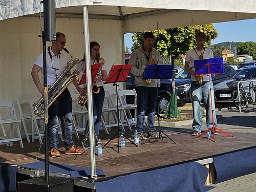 Ein Saxophonensemble spielt unter einem Pavillion.